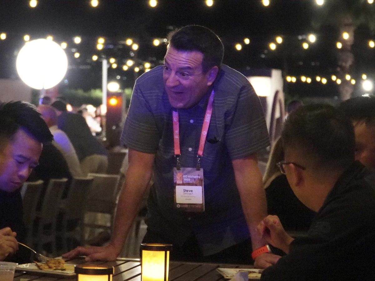 Members laughing over dinner at EO Alchemy