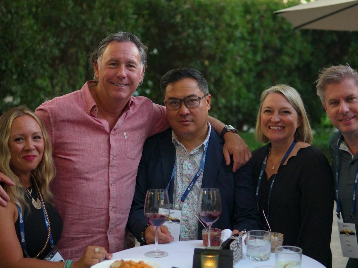 EO members arm in arm at a retreat dinner in Sonoma